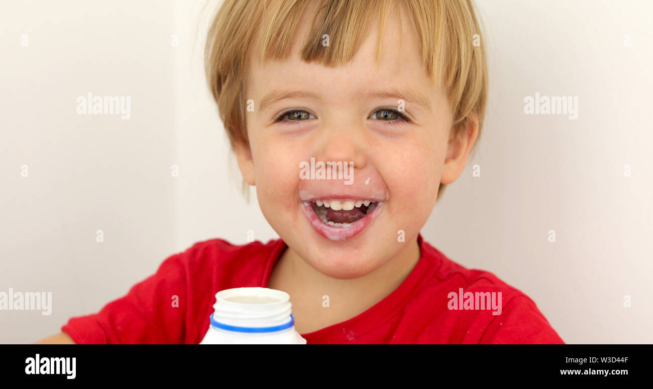 Joyful child drinking yogurt Stock Photo