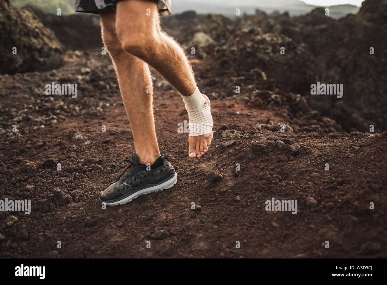Man's ankle in compression bandage. Leg injury while trail running