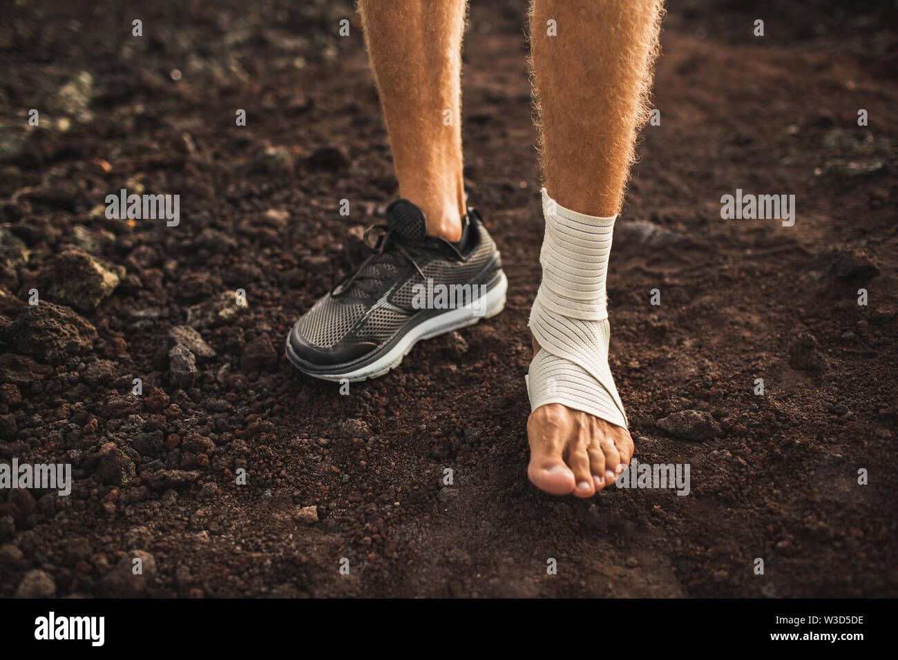 Man's ankle in compression bandage. Leg injury while trail running
