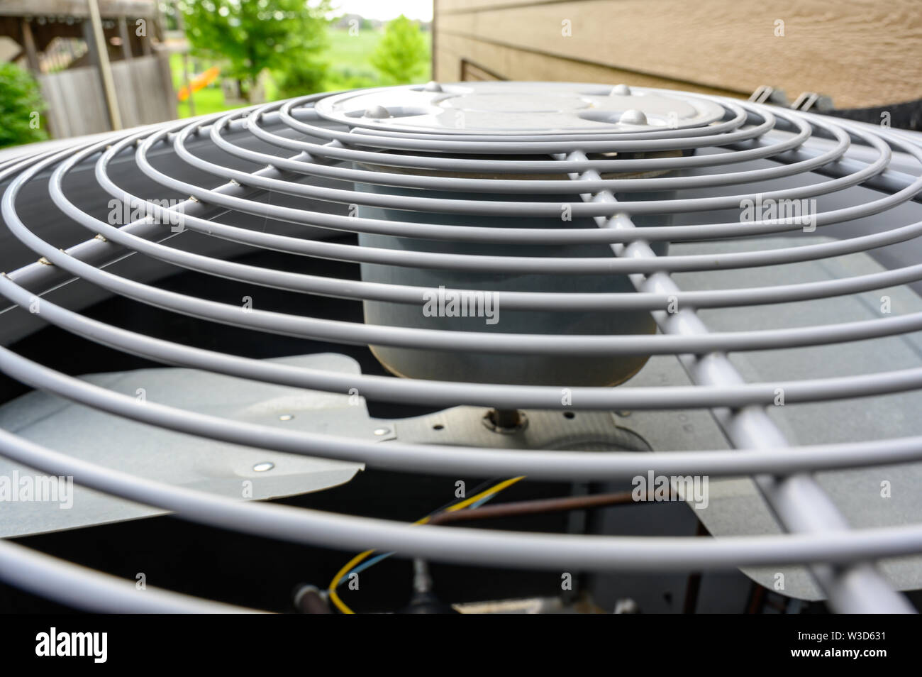 Residential air conditioning unit outdoors with fan and coils Stock