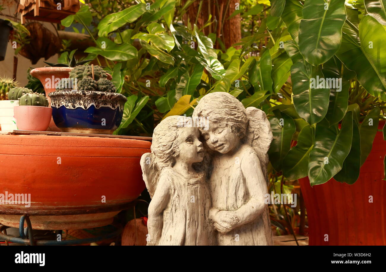 Closeup of two angel lover statues standing together in the garden, love concept Stock Photo