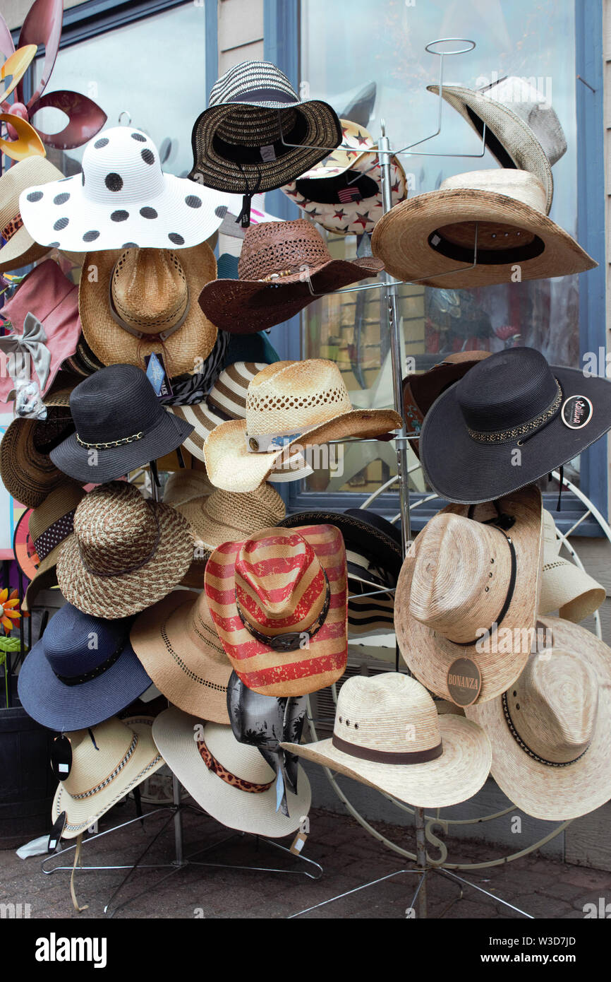 A rack of hats for sale in front of a gift shop. Stock Photo