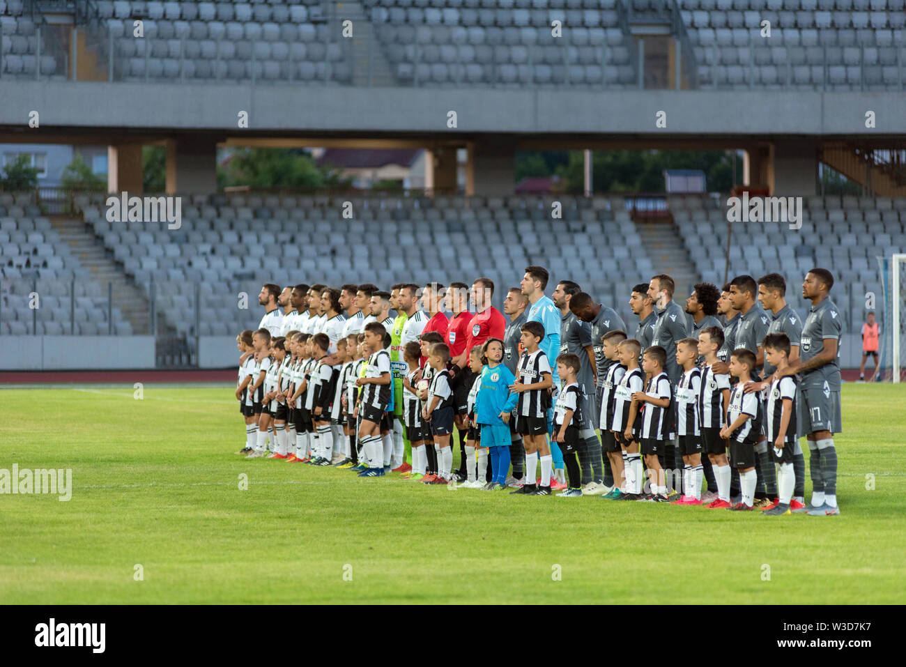 CLUJ NAPOCA, ROMANIA - JULY 12, 2019: Soccer players of Universitatea Cluj and PAOK Saloniki entering the field at the beginning of a friendly footbal Stock Photo