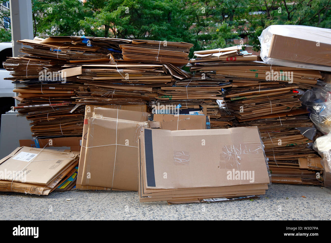 Stacks of discarded cardboard waiting for trash pickup and recycling