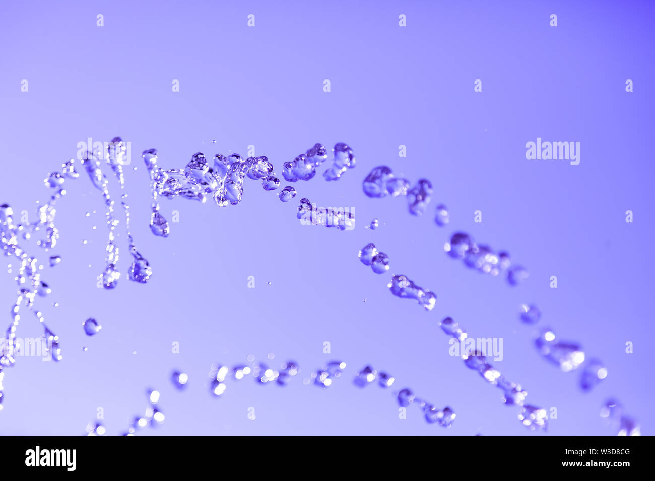 Water droplets frozen in the air with splashes and chain bubbles on a