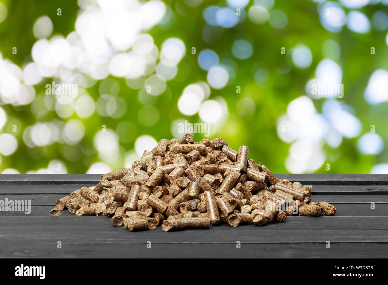 Wood pellets on a green background. Biofuels Stock Photo - Alamy