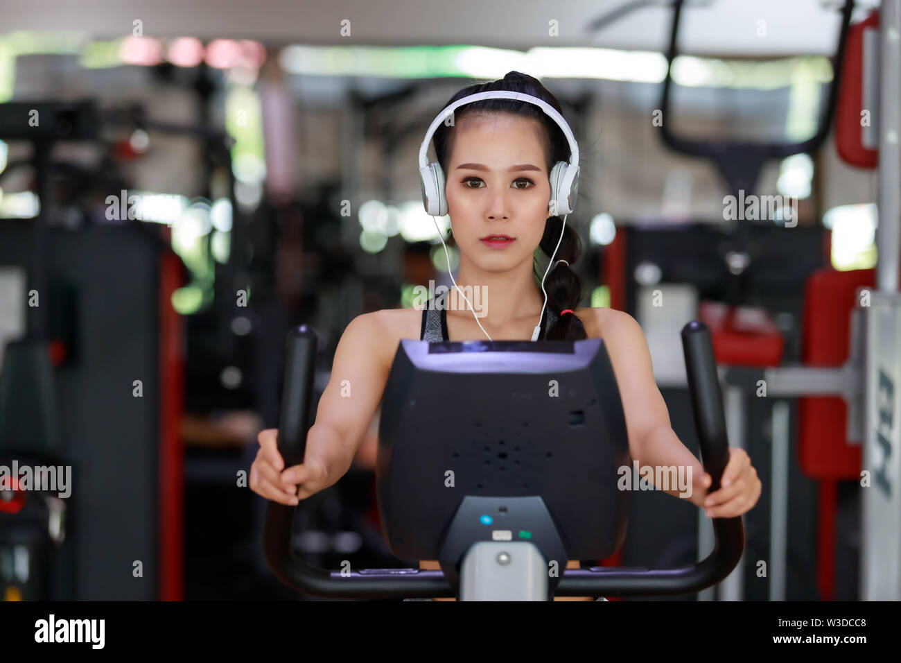 Fitness woman wearing headphone cardio workout at fitness gym Stock