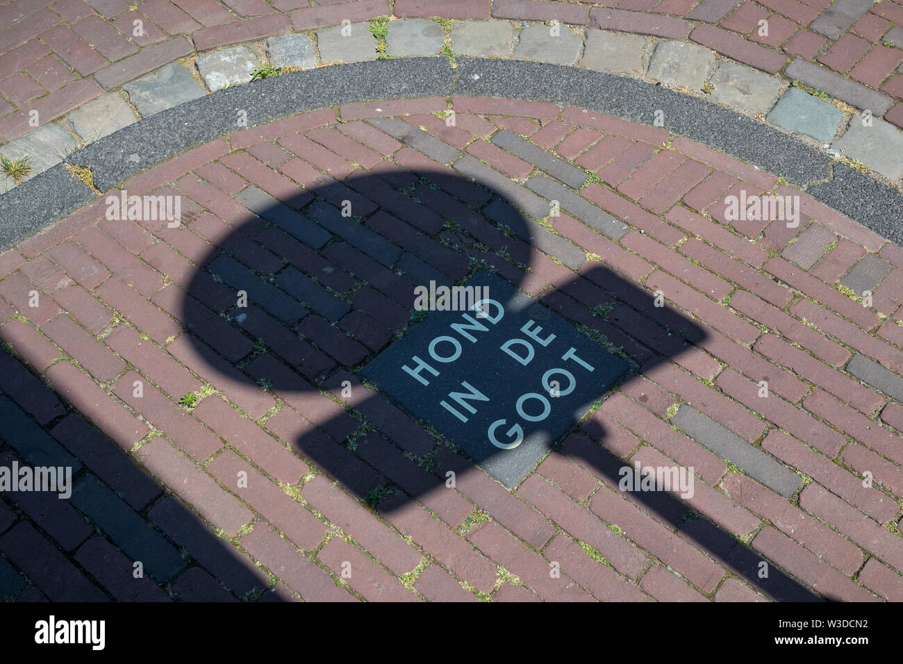 Leiden, Holland - July 05, 2019: Paving stone with dutch text which means Dog in the gutter, warning owners of dogs to let them defecate in the street Stock Photo