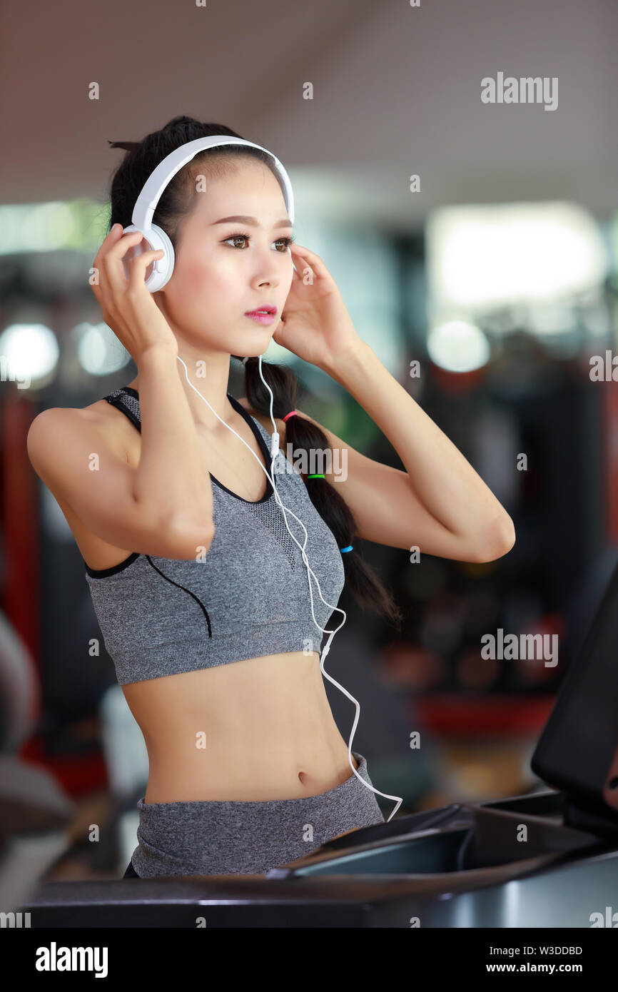 Fitness woman wearing headphone cardio workout at fitness gym Stock