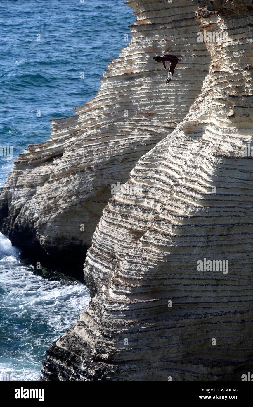 Beirut, Lebanon. 14th July, 2019. A cliff diver jumps from the landmark Rouche sea rock during the Red Bull Cliff Diving World Series in Beirut, Lebanon, July 14, 2019. Credit: Bilal Jawich/Xinhua/Alamy Live News Stock Photo