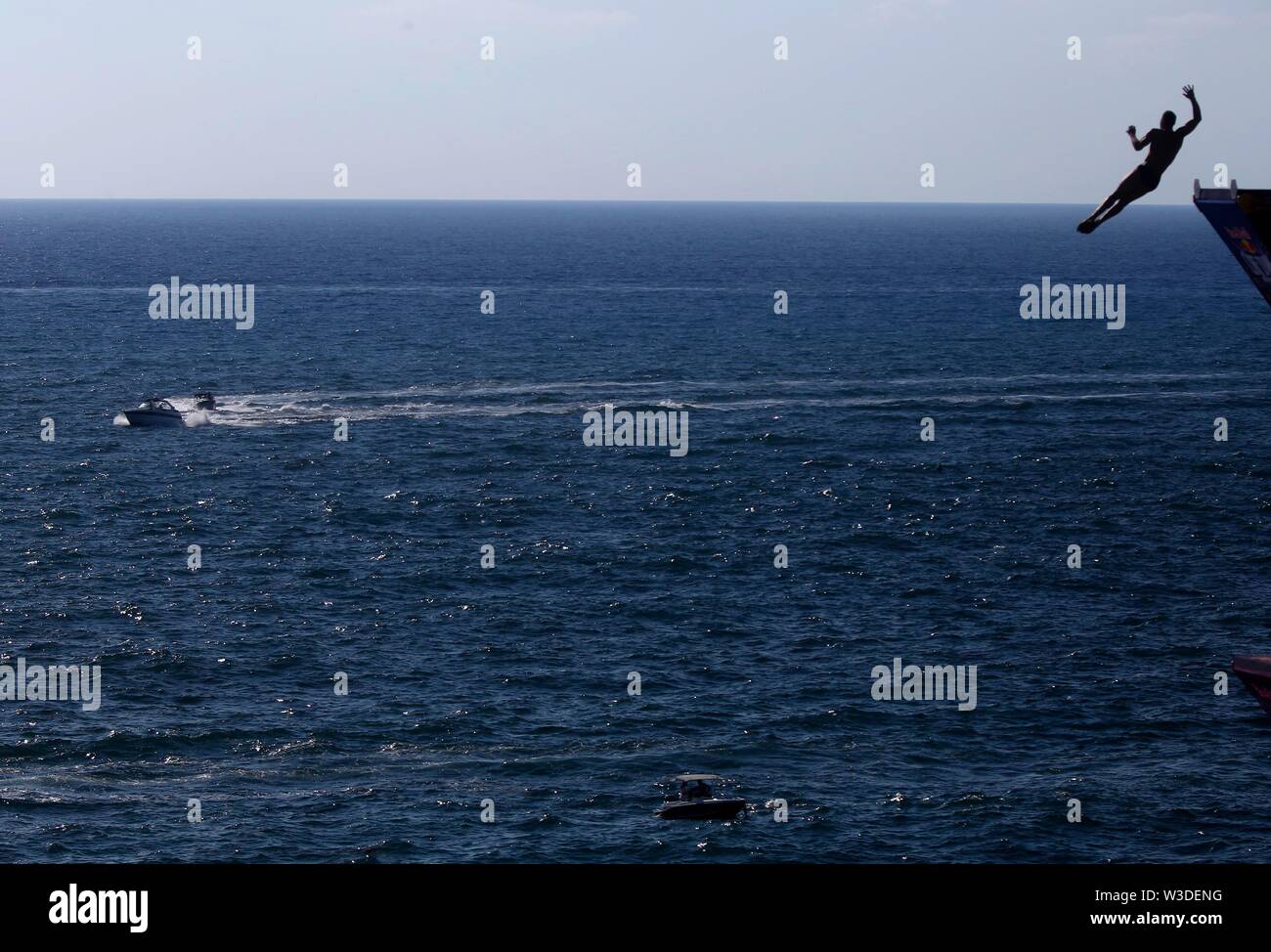 Beirut, Lebanon. 14th July, 2019. A cliff diver jumps from the landmark Rouche sea rock during the Red Bull Cliff Diving World Series in Beirut, Lebanon, July 14, 2019. Credit: Bilal Jawich/Xinhua/Alamy Live News Stock Photo