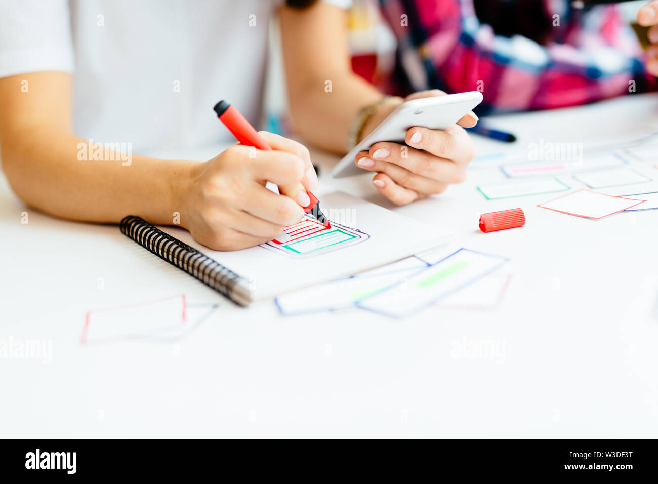 Two designers developing mobile application framework on notebook Stock Photo
