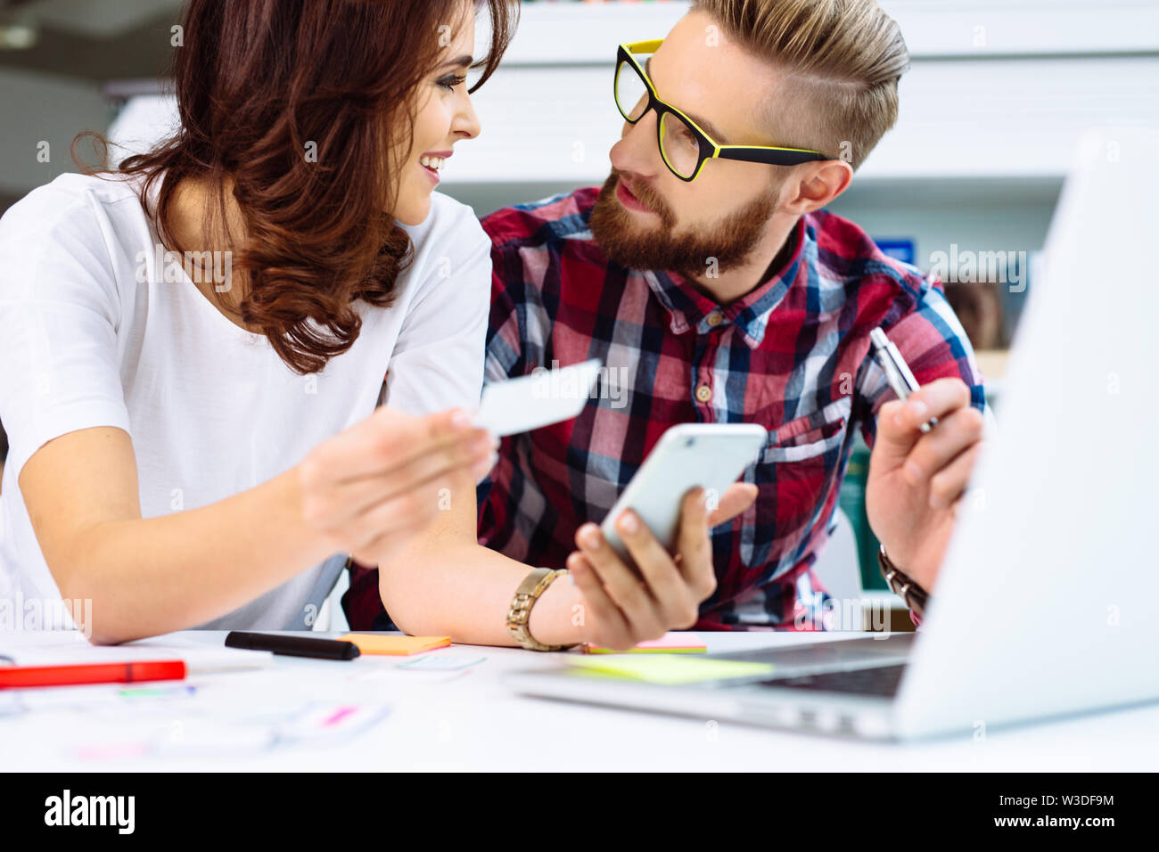 Couple of web designers working together at modern office, prototyping smartphone app Stock Photo