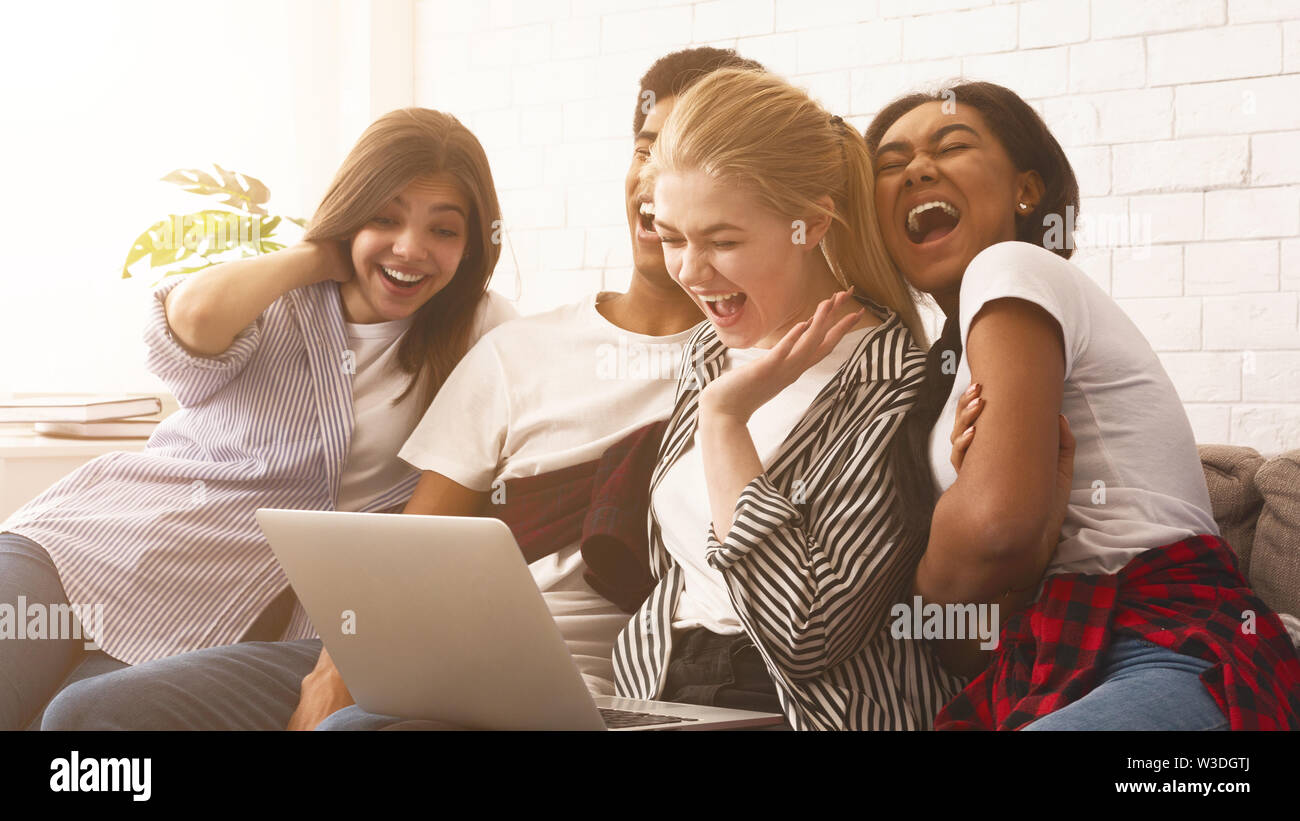 Teen friends watching funny video on laptop Stock Photo