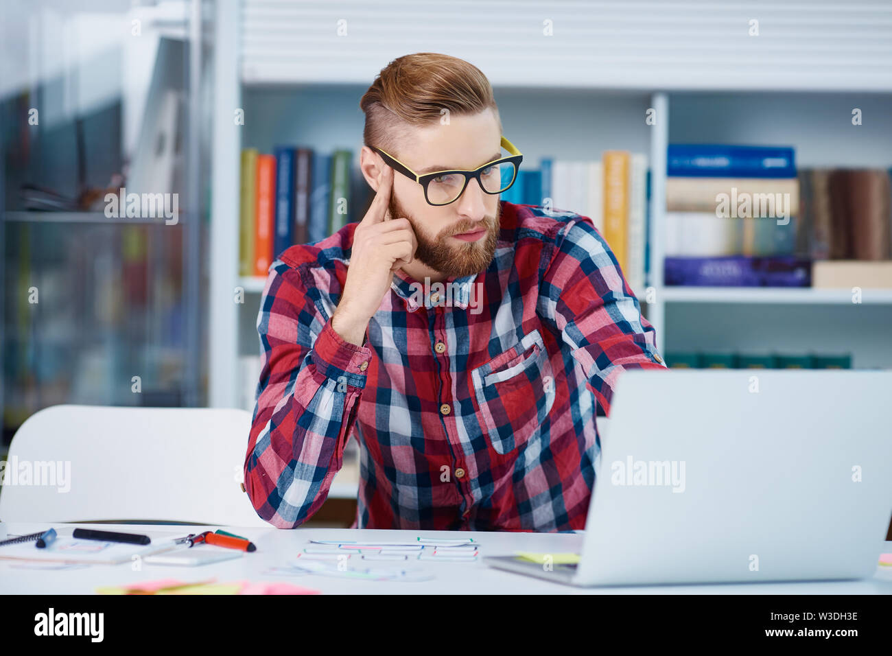 Designer checking online resources for new startup website Stock Photo