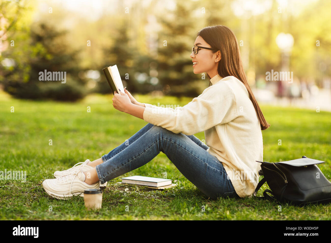 Girl preparing for lectures, reading book in college campus Stock Photo
