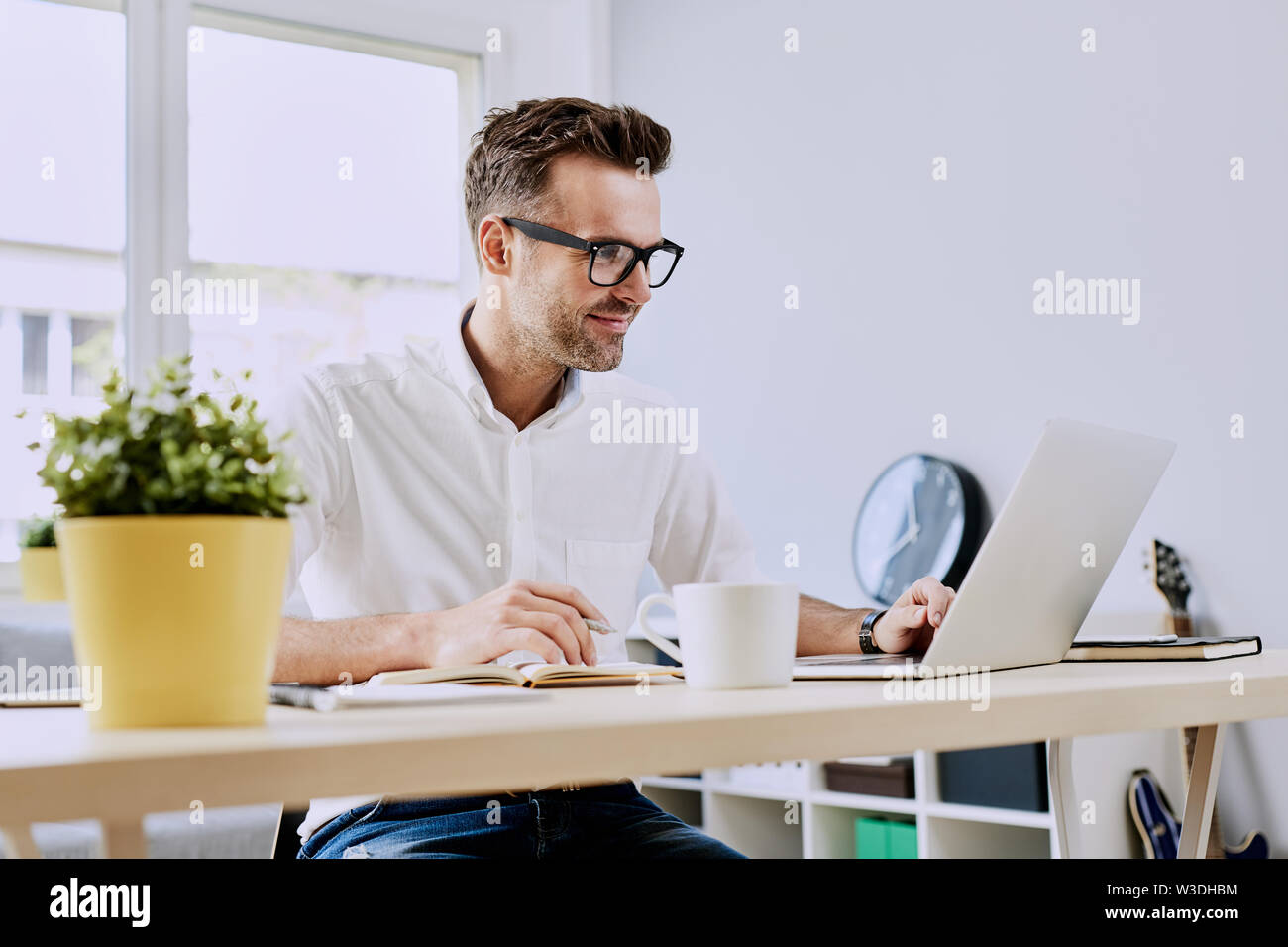 Happy man working on laptop from home office Stock Photo