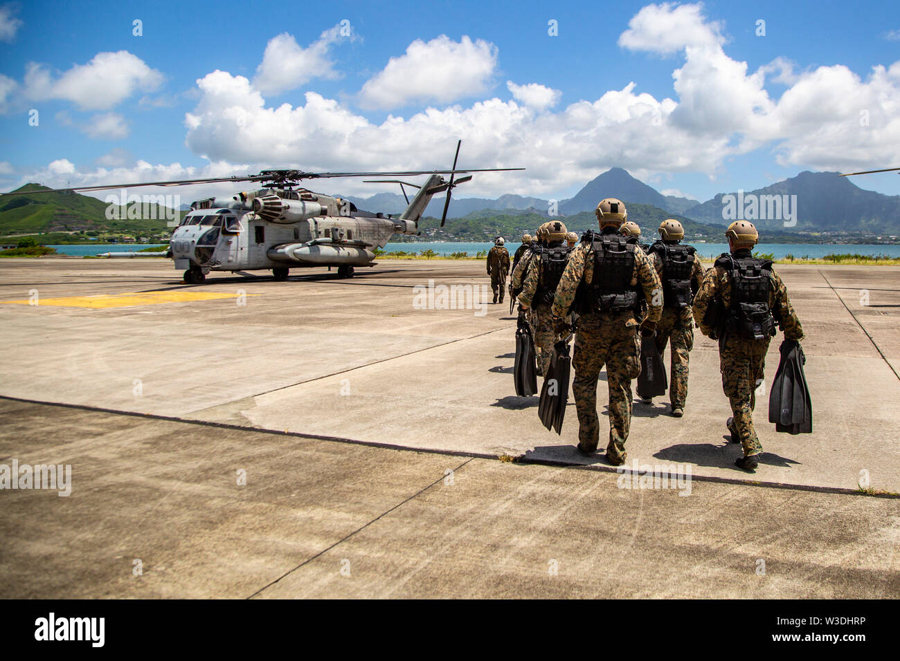 U.S. Marines with 2nd Reconnaissance Battalion make their way to the CH-53E Super Stallion Helicopter with Marine Heavy Helicopter Squadron 463 (HMH-463) for helocast training on Marine Corps Air Station, Kaneohe Bay, July 11, 2019. 2nd Reconnaissance Battalion conducted the training in preparation for their deployment with the 22nd Marine Expeditionary Unit. (U.S. Marine Corps photo by Cpl. Eric Tso) Stock Photo