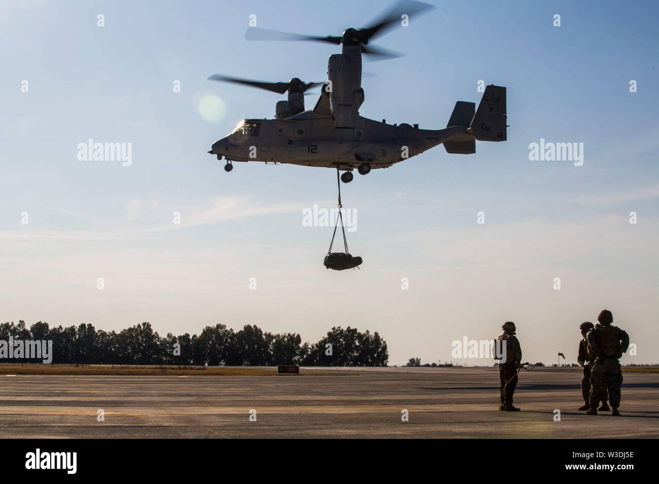 A U.S. Marine Corps MV-22B Osprey with Special Purpose Marine Air-Ground Task Force-Crisis Response-Africa 19.2, Marine Forces Europe and Africa, conducts an external lift during helicopter support team training on Moron Air Base, Spain, July 9, 2019. The exercise was conducted to increase interoperability between the aviation combat element and logistics combat element. SPMAGTF-CR-AF is deployed to conduct crisis-response and theater-security operations in Africa and promote regional stability by conducting military-to-military training exercises throughout Europe and Africa. (U.S. Marine Cor Stock Photo
