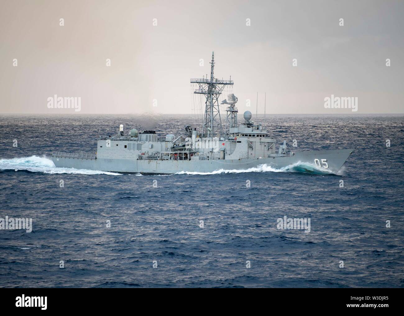 190711-N-WK982-1094 Coral Sea (July 11, 2019) The Royal Australian Navy Adelaide-class guided-missile frigate HMAS Melbourne (FFG 05) maneuvers into formation during Talisman Sabre 2019. Talisman Sabre 2019 illustrates the closeness of the Australian and U.S. alliance and the strength of the military-to-military relationship. This is the eighth iteration of this exercise. (U.S. Navy photo by Mass Communication Specialist 2nd Class John Harris/Released) Stock Photo