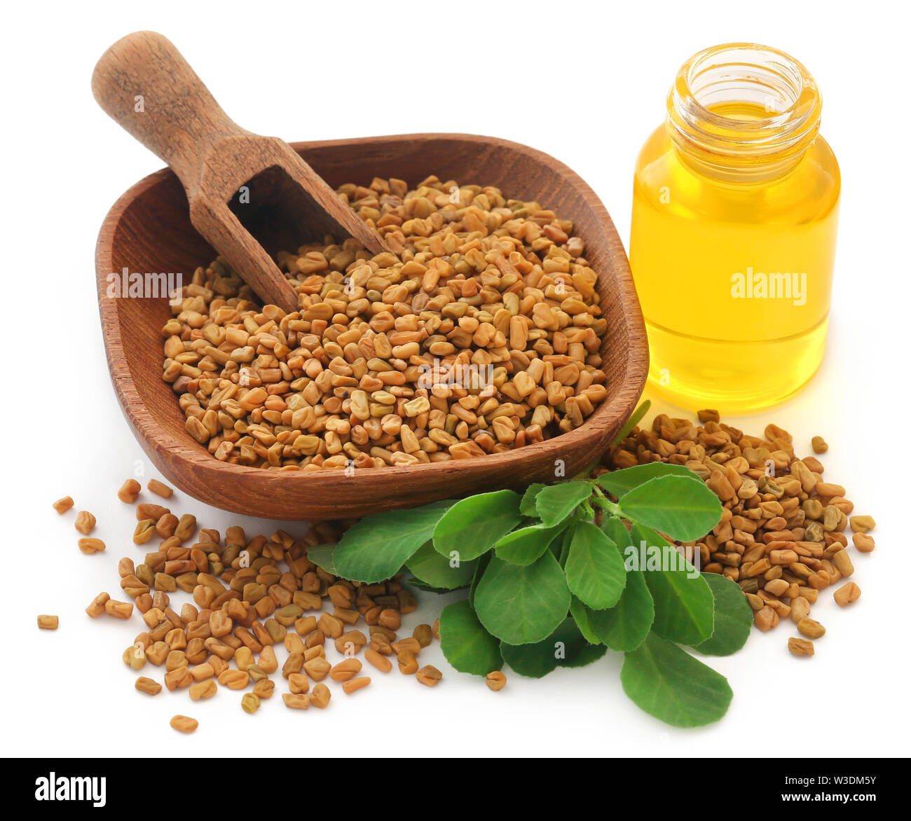 Fenugreek seeds with oil in bottle over white background Stock Photo