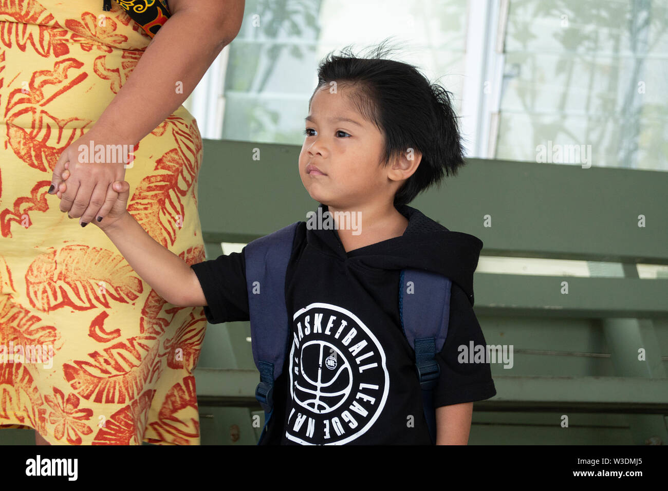 Candid portrait of a young Polynesian boy holding his mother's hand, Cook Islands, Polynesia Stock Photo