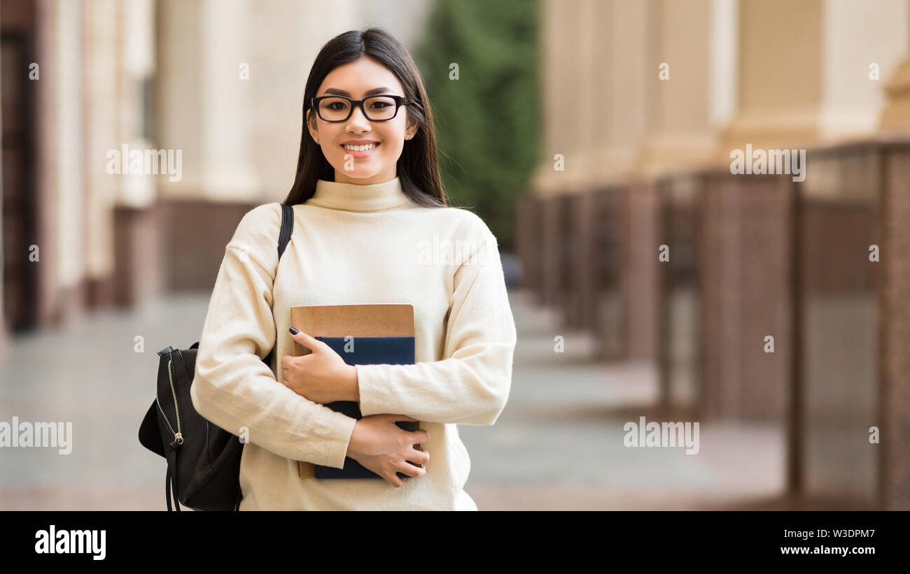 Happy college student with books in campus Stock Photo