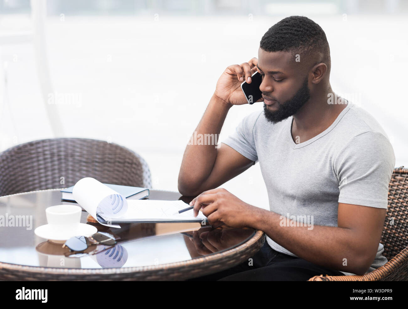 Concentrated african businessman checking his data in notepad Stock Photo