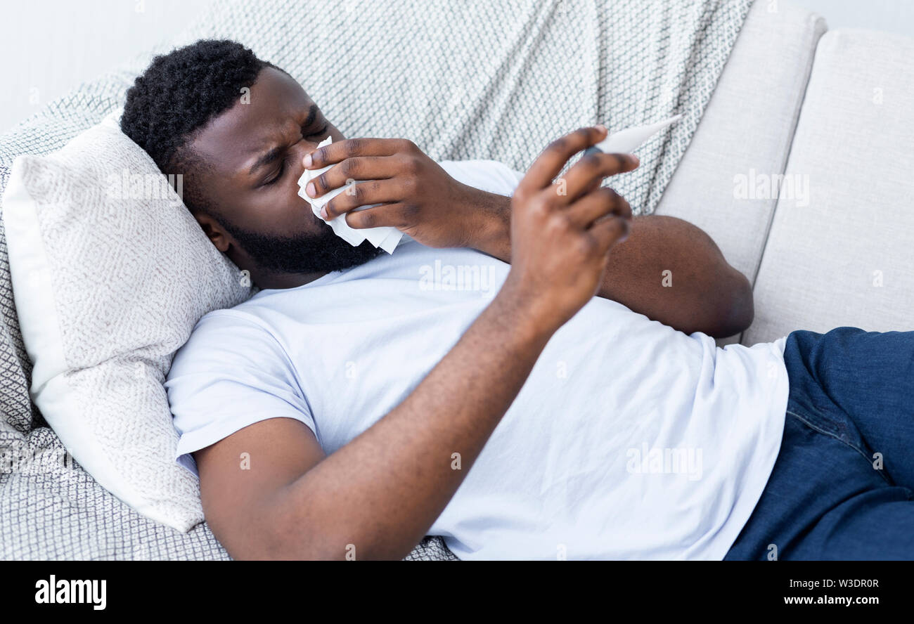 African-american man man has runny nose at home Stock Photo