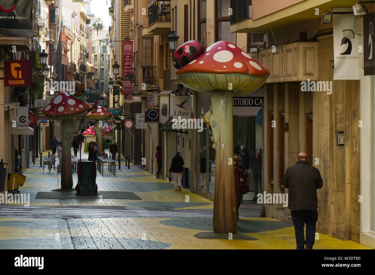 Carrer de Sant Francesc in Alicante, Spain. City street with unusual sculptures of mushrooms and fungi with insects. Stock Photo