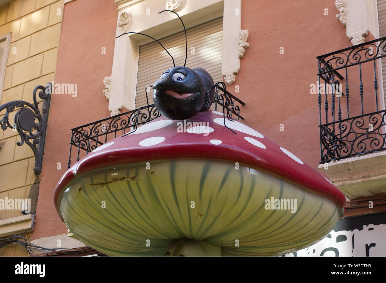 Carrer de Sant Francesc in Alicante, Spain. City street with unusual sculptures of mushrooms and fungi with insects. Stock Photo