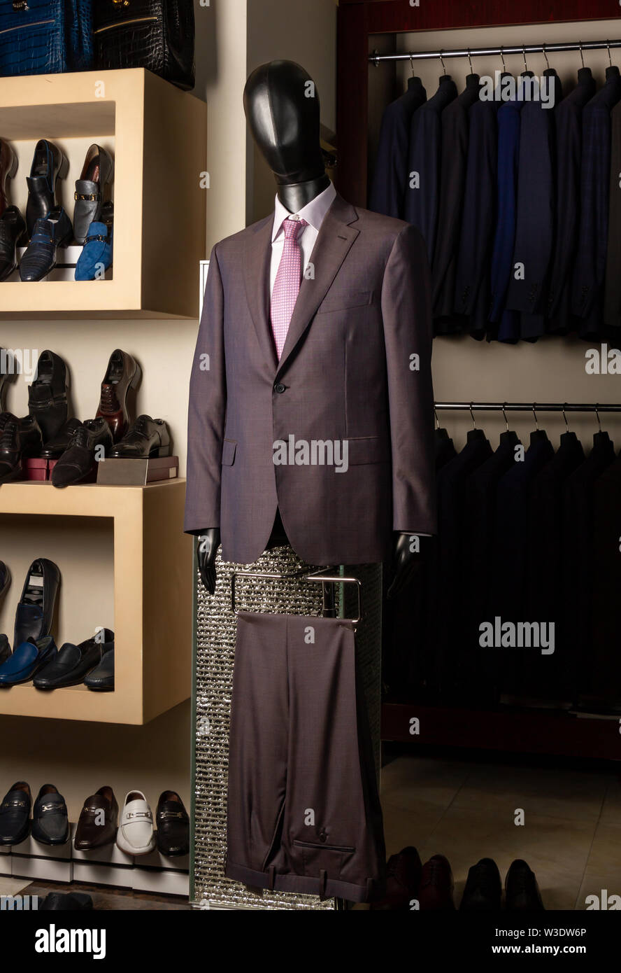 Black leather mannequin showing a classic men's suit on the background