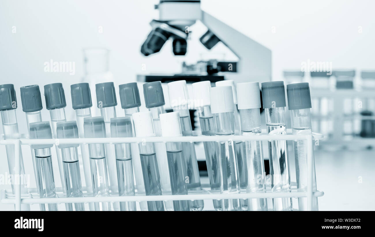 Microscope and test tubes on laboratoy table Stock Photo - Alamy