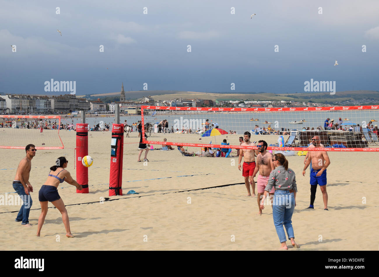 People playing beach volleyball in Summer on Weymouth Beach in the UK Stock Photo