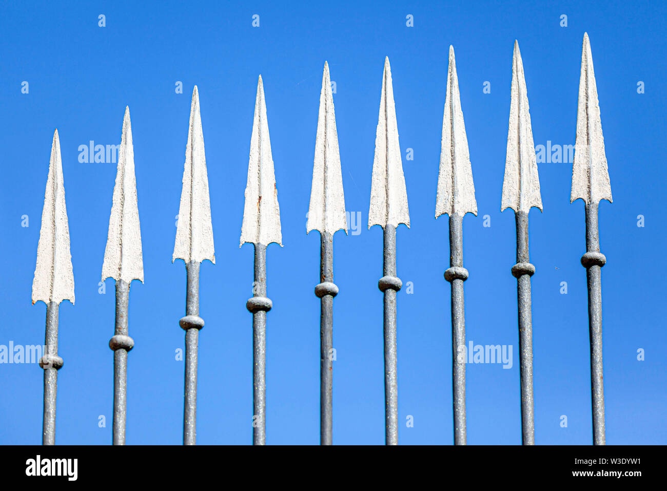 Nine arrows from a iron gate and blue sky. Stock Photo