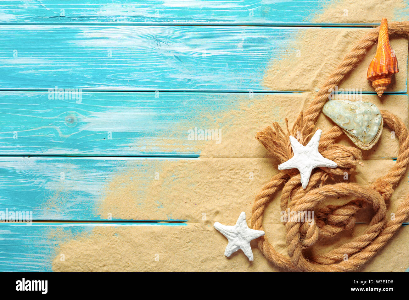 Sea Shell On Ropes sea rope with many different sea shells on the sea sand on a blue ...