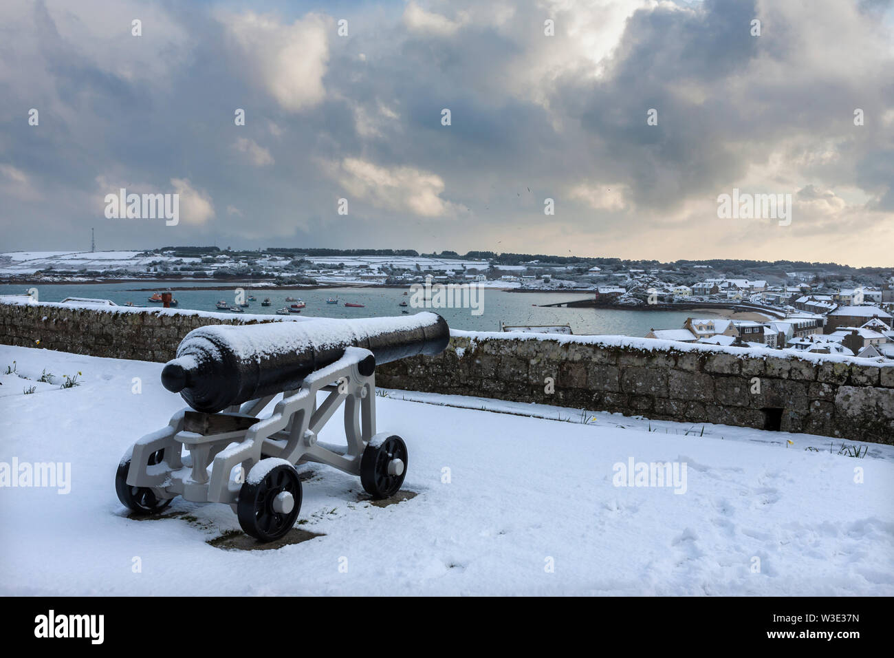 Cannon in Duke of Leeds' Battery (aka the Garden Battery), Garrison, Hugh Town, Isles of Scilly, UK, looking over St. Mary's Pool, during a snowstorm Stock Photo