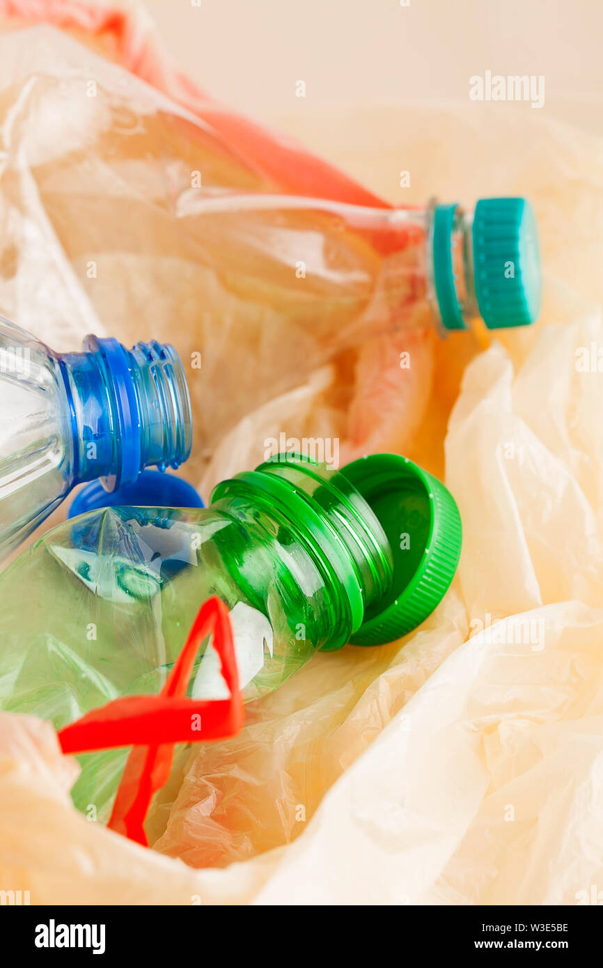 Used empty plastic water bottles crushed and crumpled in garbage bag for sorting (segregating) and recycling close-up.Environment pollution Stock Photo