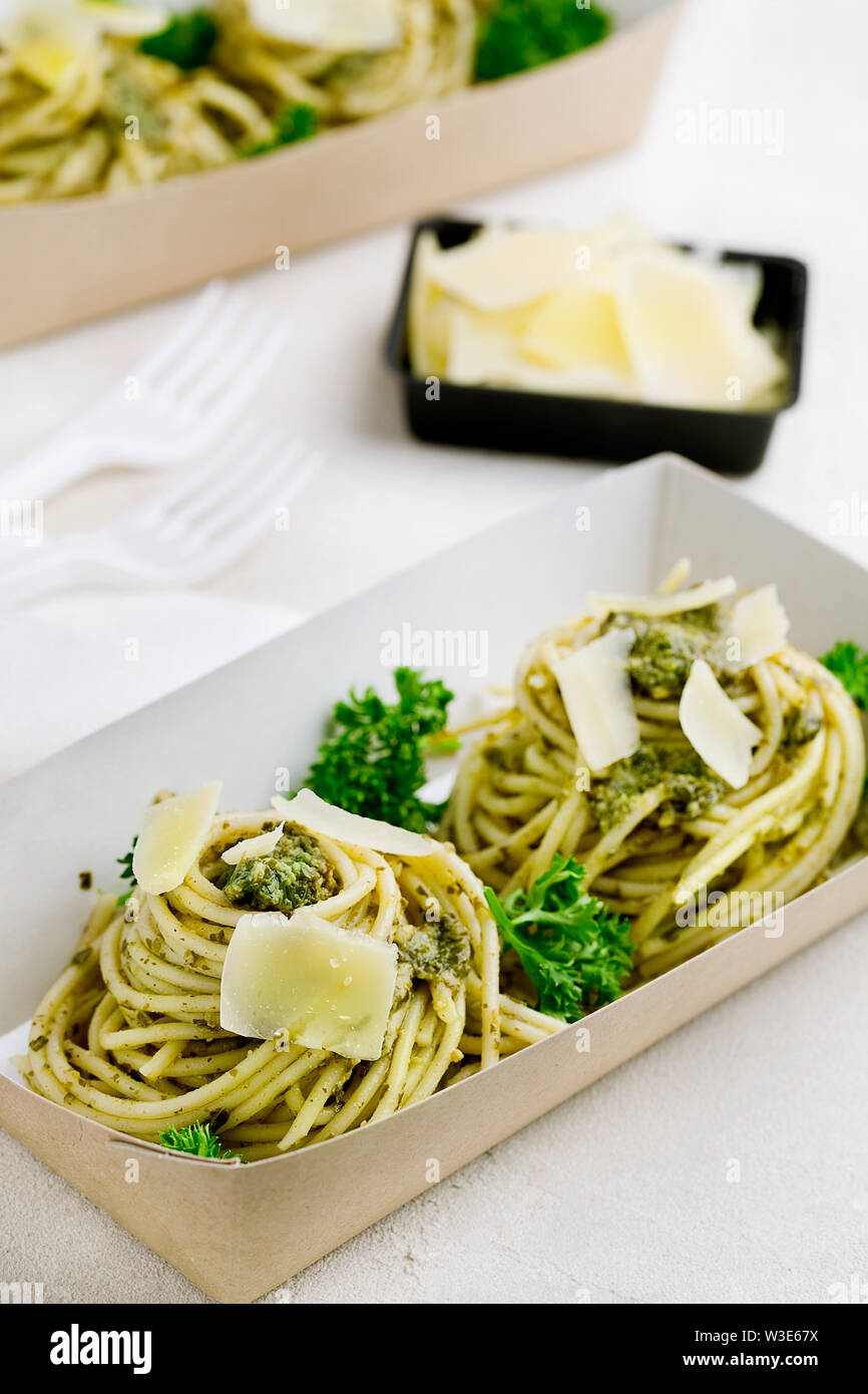 Pasta with pesto sauce decorated with parmesan and curly parsley in a
