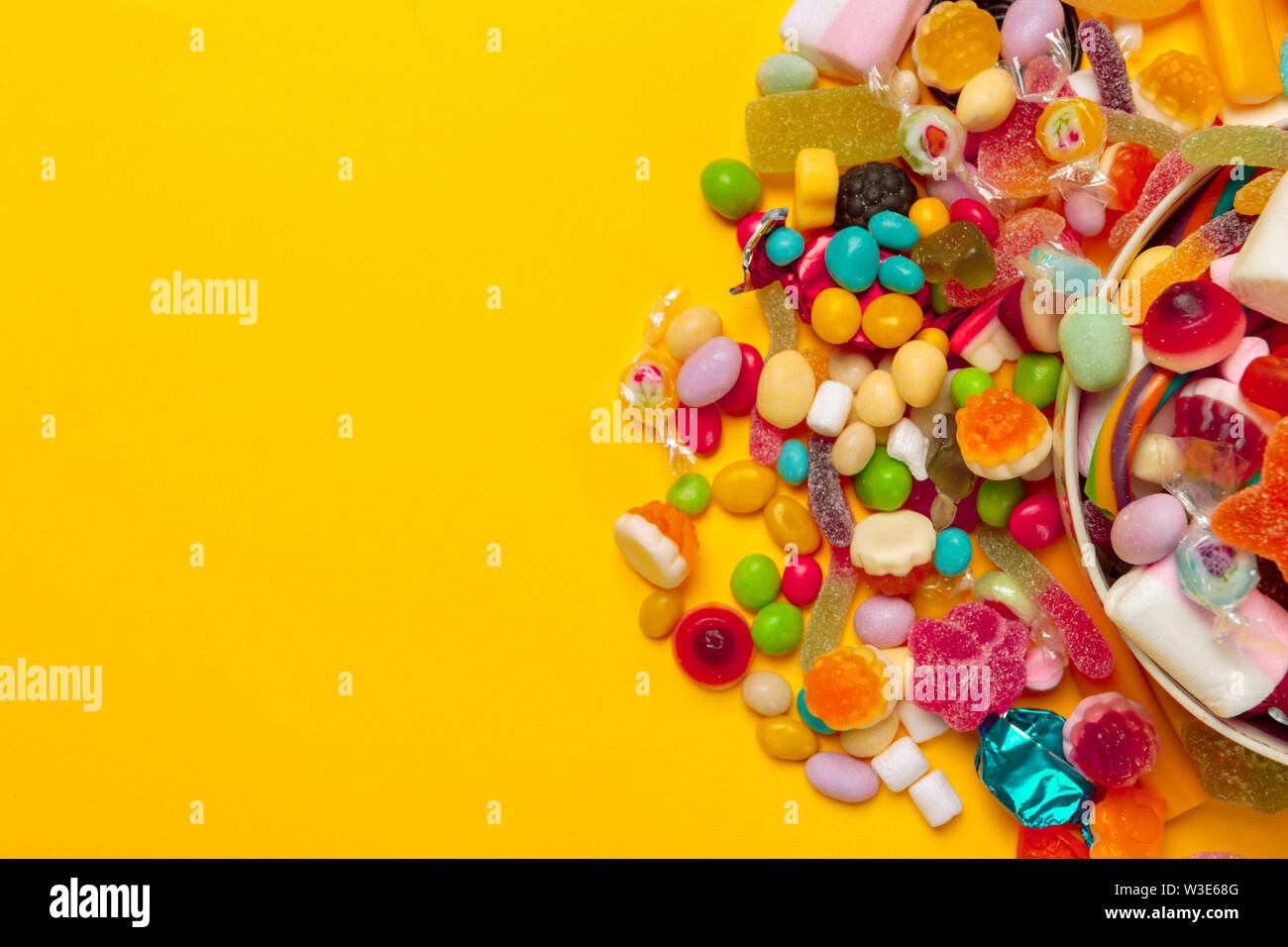 colored candies on yellow background Stock Photo
