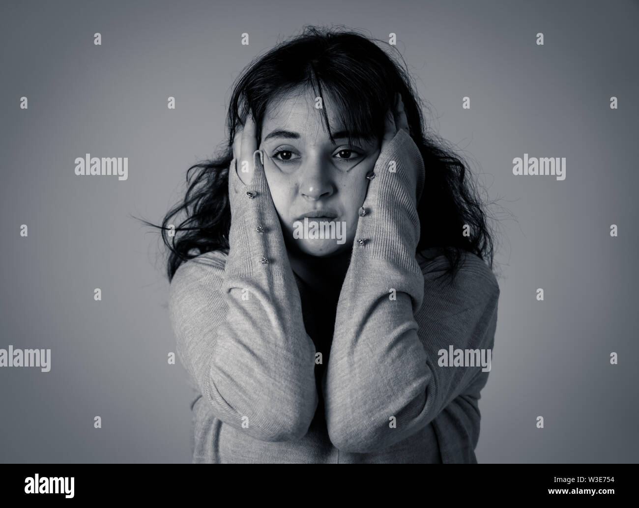 Close up portrait of beautiful young woman with sad eyes looking