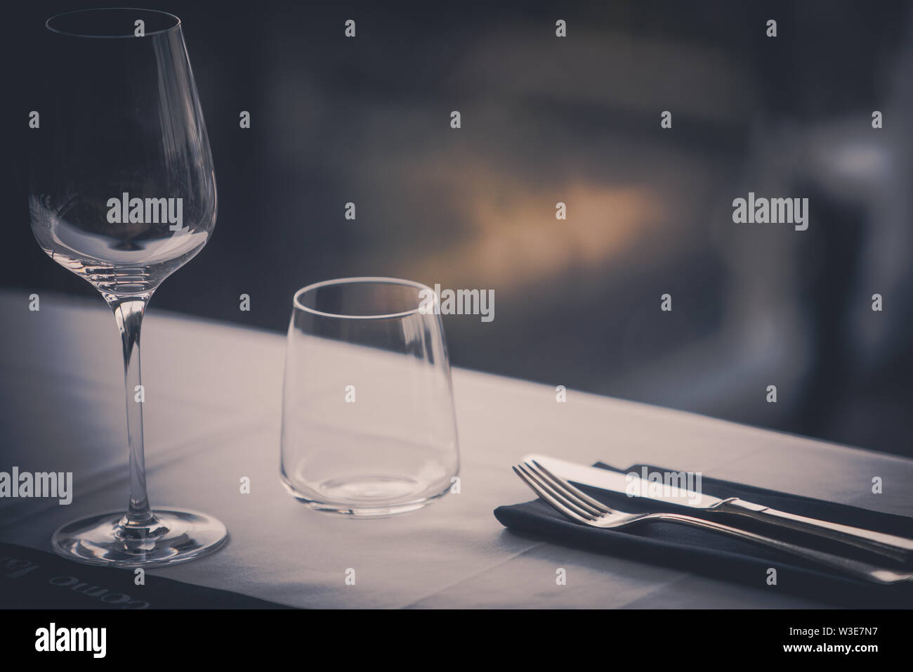 Empty glasses and dish ware on a table in a restaurant Stock Photo - Alamy