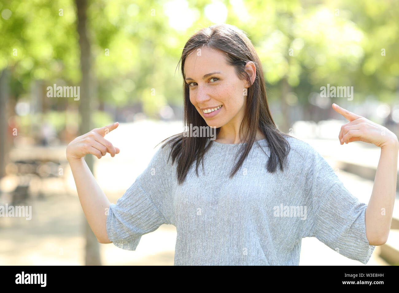 Proud woman pointing herself with both hands standing in a park Stock Photo