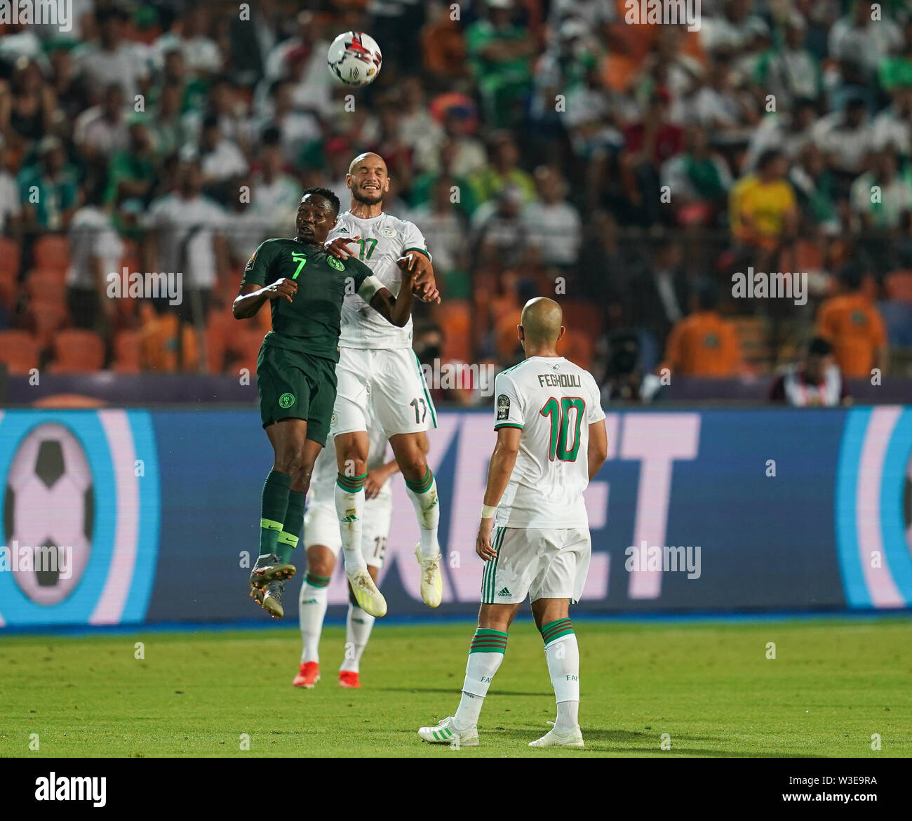 Cairo, Algeria, Egypt. 14th July, 2019. FRANCE OUT July 14, 2019: Ahmed Musa of Nigeria and Adlane Guedioura of Algeria challenging for the ball during the 2019 African Cup of Nations match between Algeria and Nigeria at the Cairo International Stadium in Cairo, Egypt. Ulrik Pedersen/CSM/Alamy Live News Stock Photo