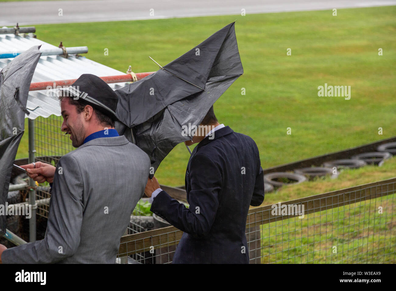 A wet and windy day at Goodwood Revival turning umbrellas inside out Stock Photo Alamy