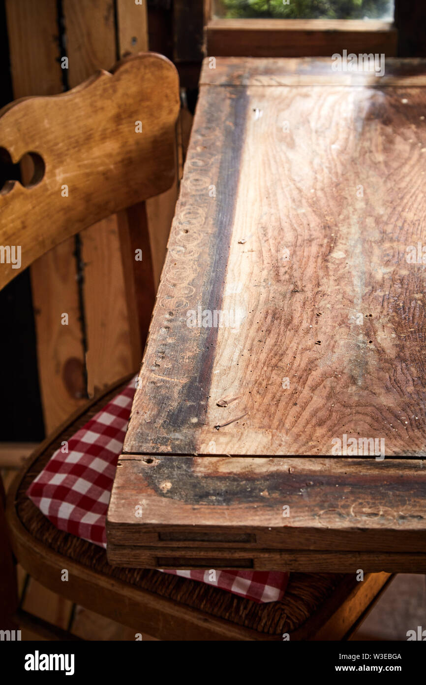 Empty Table Inside Shack Old rustic bare empty table and chair in front of a window in a tavern ...