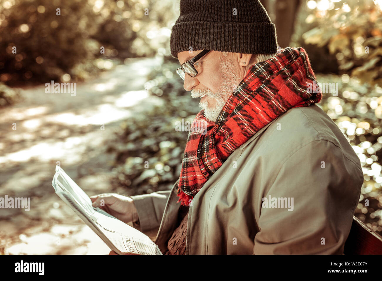 Handsome aged man reading a newspaper in the park Stock Photo - Alamy