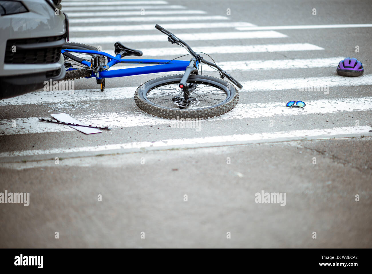 Scene of a road accident with car and broken bicycle lying on the