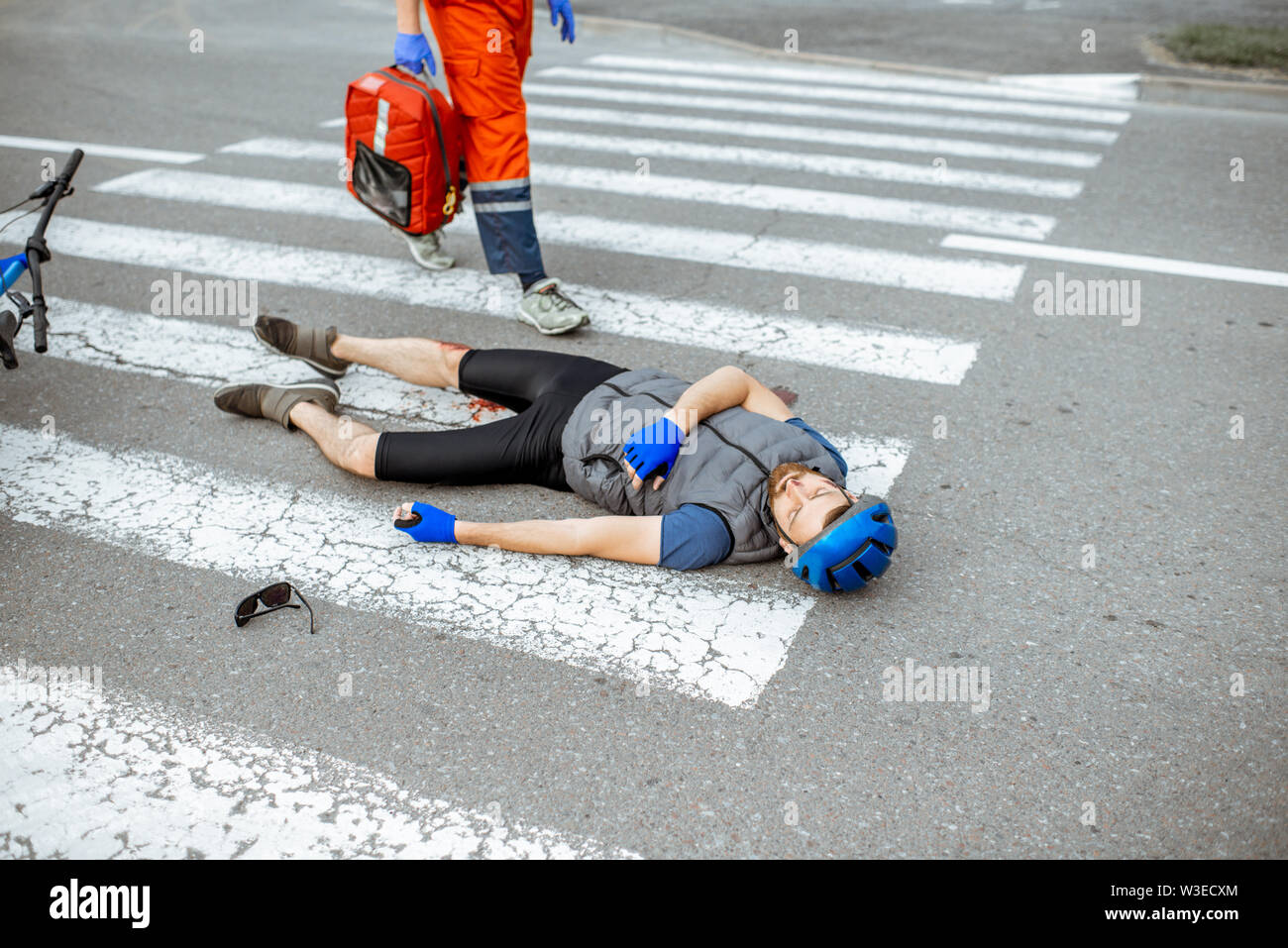 Road accident with injured cyclist lying on the pedestrian crossing ...