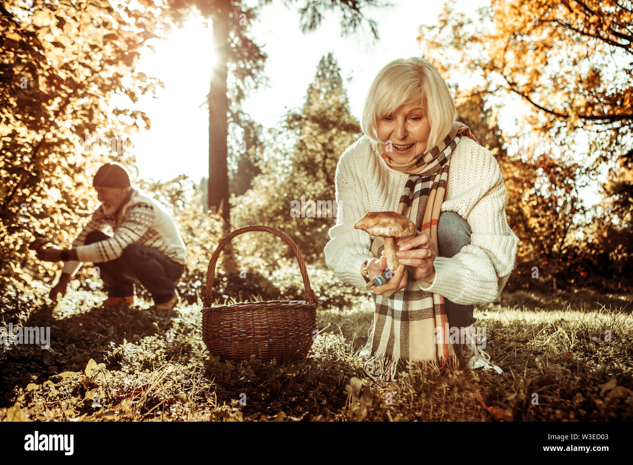 Senior woman being glad about her finding. Stock Photo